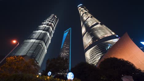 Three-tallest-skyscrapers-of-Shanghai-illuminated-at-night,-China