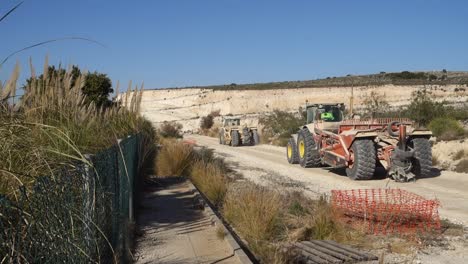 John-Deere-tractors-towing-earth-moving-equipments-on-builing-site-near-Torrevieja,-Spain