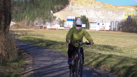 Frau-Mit-Maske-Beim-Radfahren-Auf-Der-Straße-In-Der-Nähe-Von-Bratislava,-Slowakei-Während-Des-Coronavirus-Ausbruchs---Slowmo