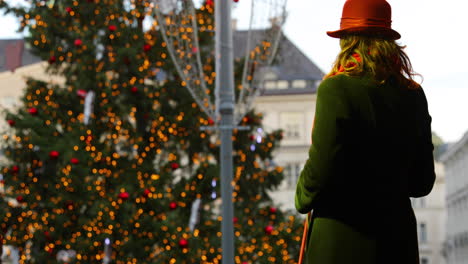 The-singer-sings-and-bowing-after-spectators-on-stage-during-a-Christmas-performance-in-green-outfit-in-background-with-a-Christmas-tree-at-Green-Square-markets-captured-at-4k-60fps-slow-motion