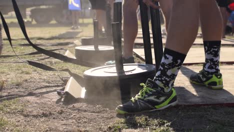 Un-Hombre-Despega-En-Una-Carrera-De-Tracción-De-Cuerda-Ponderada-En-Una-Competencia-De-Crossfit,-Un-Ejercicio-Utilizado-Para-Perder-Peso,-Desarrollar-Fuerza-Y-Resistencia-Cardiovascular,-Empujar-Y-Tirar-De-Entrenamiento-Con-Pesas