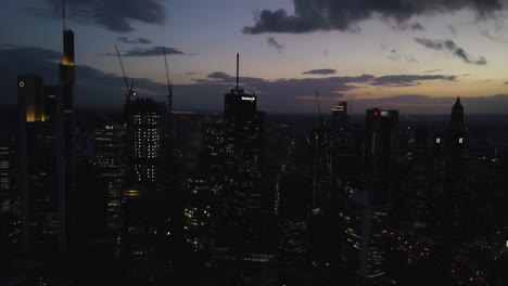 Night-view-of-skyscrapers-in-downtown-business-district-near-river-in-Germany