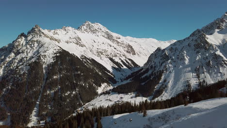 Un-Telesilla-Solitario-Que-Transporta-A-Esquiadores-Por-Laderas-Cubiertas-De-Nieve-Debajo-De-La-Cordillera-De-Montafon,-Alpes-Austriacos,-Cámara-Lenta