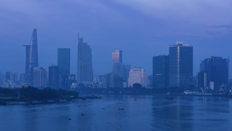 4K-Zeitrafferansicht-Des-Finanzzentrums-Und-Der-Skyline-Der-Stadt-Von-Einer-Brücke-über-Den-Saigon-Fluss