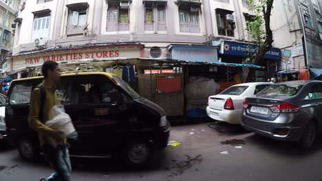 Busy-street-of-Mumbai,-markets-open-and-people-shopping,-crossing-street