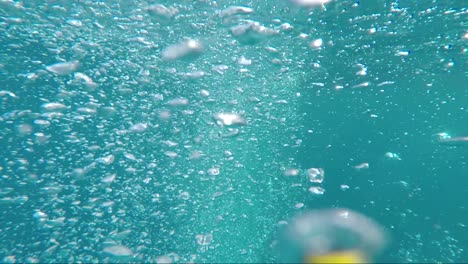 Nadando-A-Través-De-Burbujas-De-Oxígeno-En-El-Océano-Azul-Profundo