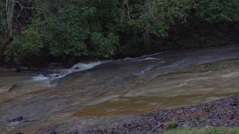 A-right-to-left-pan-and-tilt-of-a-stream-running-under-a-red-covered-bridge