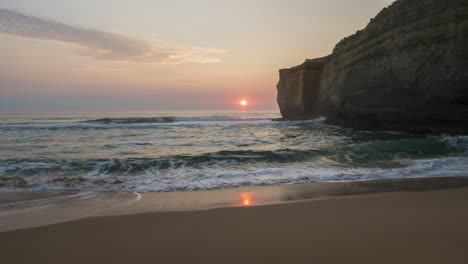 Timelapse-of-sun-setting-over-the-ocean-and-horizon-behind-a-cliff-near-Port-Campbell,-Victoria,-Australia,-December-2019