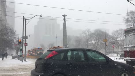 Streetcars-drive-by-plows-at-intersection-during-snowstorm,-Toronto