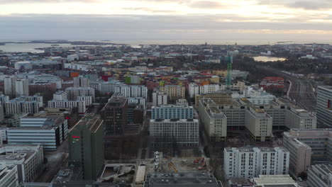 Aerial,-drone-shot-over-the-Mall-of-Tripla-towards-downtown-Helsinki,-on-a-cloudy-evening,-in-Uusimaa,-Finland