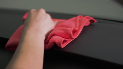 A-man-cleaning-off-a-dashboard-of-a-car-with-a-microfiber-cloth