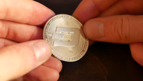 Holding-a-physical-mockup-of-the-cryptocurrency-Dashcoin