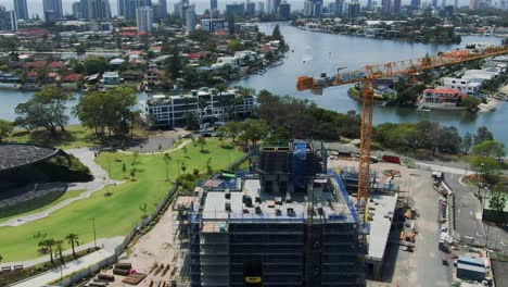 HOTA-gallery-construction-site,-drone-view-of-crane-on-a-bright-day-,-view-of-Surfers-Paradise-and-canals