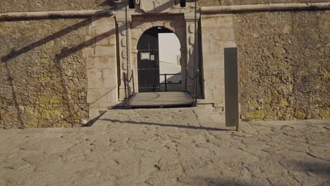 Disparo-En-Cámara-Lenta-Acercándose-A-La-Entrada-Del-Castillo-De-Lagos-Con-Un-Puente-Levadizo-Sobre-Un-Foso-En-Un-Día-Soleado