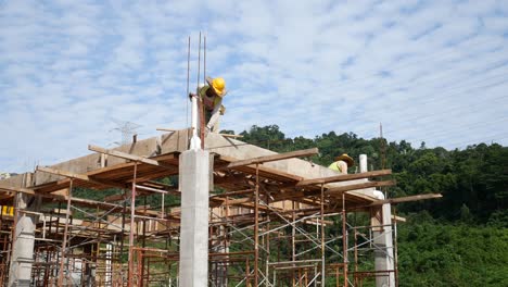 Bauarbeiter,-Die-Auf-Der-Baustelle-Holzschalungen-Und-Regenwasserrohre-Installieren