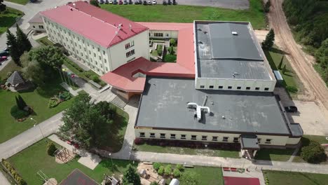 Aerial-view-of-school-building,-with-the-playground-next-to-it---ORBITAL-movement-to-the-RIGHT