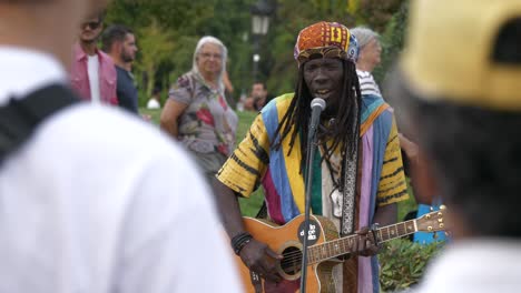 Colourful-street-performer-busker-artist,-singing---playing-guitar-in-Barcelona,-Spain