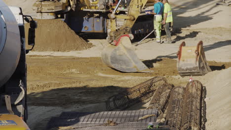 Brazo-De-Excavadora-Recogiendo-Tierra-En-Un-Sitio-De-Construcción-En-Viena,-Austria,-Con-Una-Topadora-En-La-Parte-Trasera