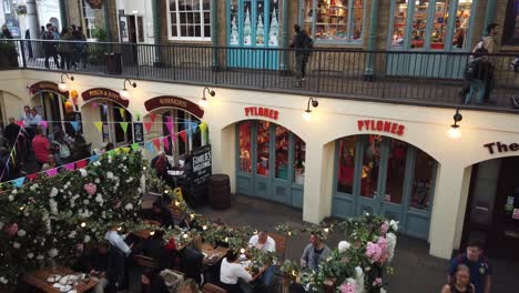 Covent-Garden-in-London,-showing-people-eating-in-restaurants-and-shopping-in-boutiques