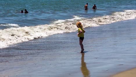 Niña-Jugando-Con-Olas-Y-Disfrutando-De-La-Costa-Del-Mar-Tropical-Exótico