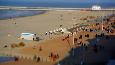 TIME-LAPSE:-Seaside-view-with-people-walking-on-the-promenade-on-a-sunny-morning-with-miniature-effect