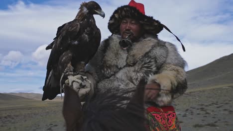 Amazing-Kazakh-eagle-hunter-with-Golden-Eagle-on-horseback,-closeup