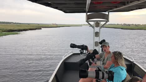 Photo-Safari-patrons-chat-during-quiet-time-on-the-Chobe-River,-Africa