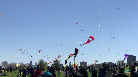 Mittlere-Aufnahme-Von-Cricket-Hill-Im-Montrose-Harbor-Mit-Leuten,-Die-Während-Des-Kids-And-Kites-Festivals-Drachen-Steigen-Lassen,-Mit-Der-Skyline-Von-Chicago-Im-Hintergrund