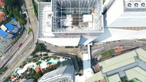 Aerial-top-down-view-of-CIMB-bank-tower-flying-backwards-tilting-up-revealing-the-background-nature-of-Kuala-Lumpur