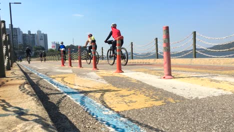 Gente-Andando-En-Bicicleta-A-Lo-Largo-De-La-Orilla-Del-Río,-Yeomchang-dong,-Gangseo-gu,-Seúl,-Corea-Del-Sur