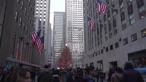 Rockefeller-Center-Christmas-Tree,-Far-Away-Eye-Level-View-with-People-Walking-By,-Families-Spending-Time-Together-During-Holiday-Season