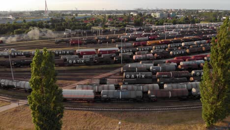 Toma-Aérea-Que-Muestra-Un-Gran-Depósito-De-Trenes-Con-Muchos-Trenes-De-Carga-Coloridos