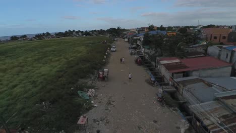 Toma-Aérea-De-Un-Dron-De-Un-Camino-De-Tierra-Azotado-Por-La-Pobreza-En-El-Barrio-De-Barangay-Cerca-De-Rosario-Cavite,-Filipinas,-Cerca-De-La-Bahía-De-Manila