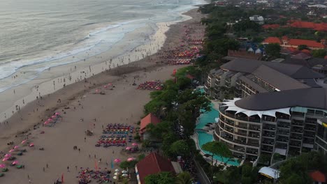 Famous-luxury-hotel-near-double-six-beach-crowded-by-tourists,-aerial,-Bali