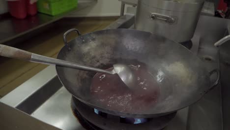 Commercial-kitchen,-giant-wok-cooking-in-slow-motion