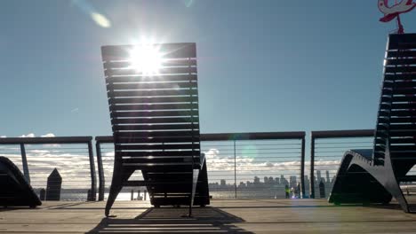 Sonne-Strömt-Durch-Liegestühle-Mit-Blick-Auf-Den-Hafen-Von-Vancouver-Und-Die-Skyline