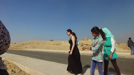 Camera-rotating-around-group-of-girls-who-are-taking-pictures-with-a-foreign-lady-next-to-the-Khafre-pyramid-in-Egypt-during-a-sunny-day