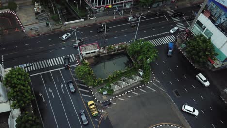 Rotonda-Y-Avenida-Con-Mucho-Tráfico-De-Automóviles-En-El-Centro-De-Bangkok,-Tailandia,-Vista-Aérea-De-Arriba-Hacia-Abajo