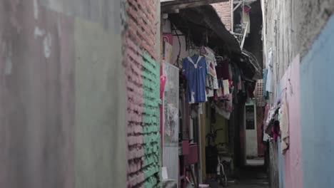 Hombre-Vestido-Con-Sudadera-Con-Capucha-Corriendo-En-Un-Callejón,-En-Algún-Lugar-Del-Sudeste-Asiático,-Yakarta