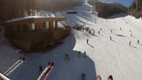 Mann-Auf-Einem-Skilift,-Der-Mit-Skifahrern-Eine-Skipiste-Hinauffährt