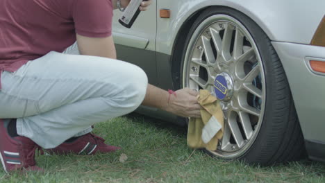 Plano-Medio-De-Un-Joven-Limpiando-El-Borde-De-Su-Auto.