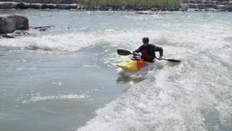 Un-Kayakista-De-Aguas-Bravas-Surfea-Una-Pequeña-Ola-De-Río