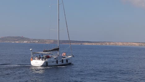 A-sailing-boat-gracefully-navigates-the-coastal-waters-of-Malta,-showcasing-the-tranquility-and-adventure-of-maritime-exploration