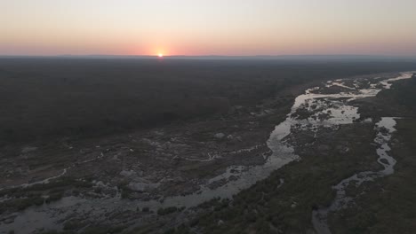 Drone-flight-over-a-large-seasonal-river-at-sunrise,-Crocodile-River,-Kruger-National-Park