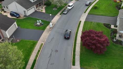 Black-Driving-car-on-road-in-American-neighborhood-at-sunset