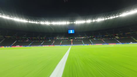 Racing-drone-rushing-over-empty-seats-onto-the-pitch-at-night-Olympic-Stadium-Berlin-UEFA-EURO2024