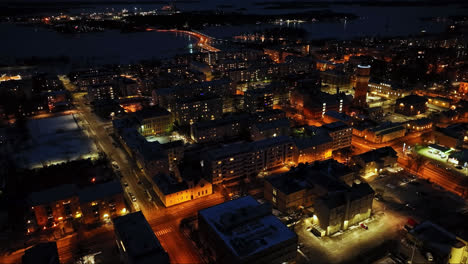 Aerial-overview-of-the-night-lit-Vaasa-city-skyline,-winter-evening-in-Finland