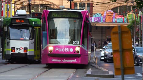 The-hustle-and-bustle-of-Melbourne-city,-with-trams-running-along-Elizabeth-street-and-Flinders-street-station-decorated-with-festive-decorations-during-Christmas-season