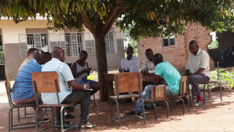 Teachers-of-Uganda-school-at-meeting-outdoors,-static-view