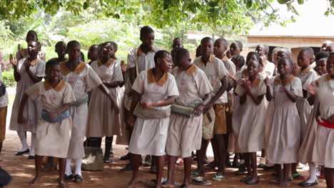Children-singing-and-dancing-under-a-tree-in-a-school-in-Kampala,-Uganda